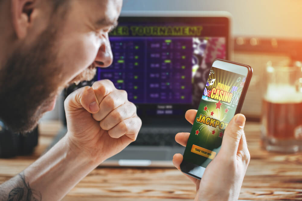 man celebrating victory after getting jackpot in online casino