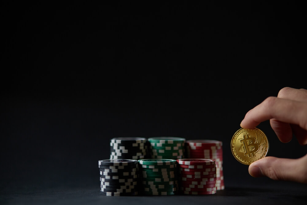 a man's hand holding a crypto coin chip