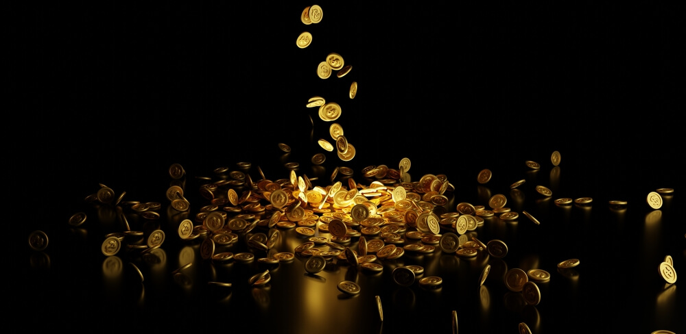 gold coins drop from sky on black background copy space